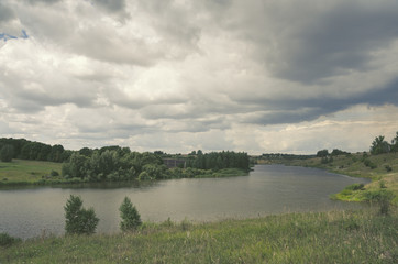 Fototapeta premium Cloudy summer landscape with river.