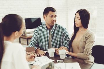 Fototapeta premium Young Man and Woman with Smiling Realtor in Office