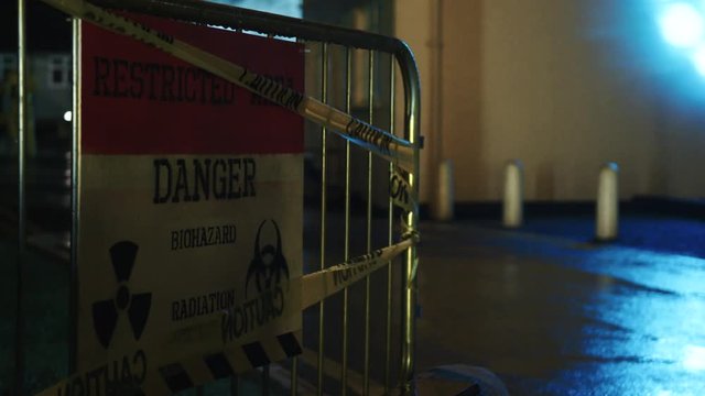 Danger, restricted access biohazard sign at night.