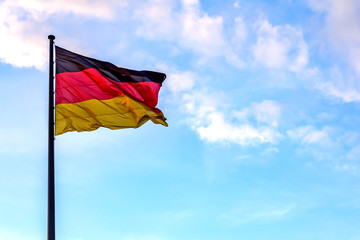 eine Deutschlandfahne vor blauem Himmel