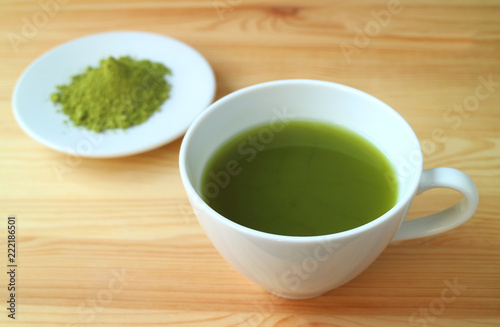 One Cup Of Vibrant Color Hot Matcha Green Tea With Blurred One Cup Of Vibrant Color Hot Matcha Green Tea With Blurred Powder In Background