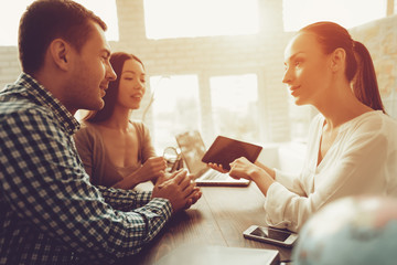 Young Man and Woman in Travel Agency with Manager.