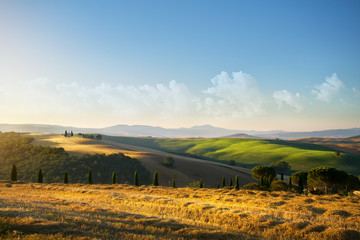 Fototapeta na wymiar typical Tuscany countryside landscape; sunset over rolling hills and Tuscany village
