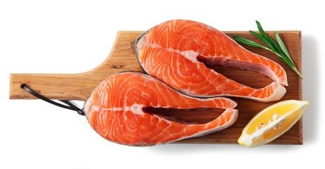 Raw salmon steak slices with spices, on a board, isolated on a white background. Top view.