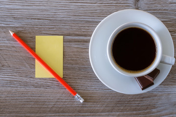 cup of coffee and notebook on wooden table