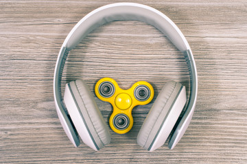 Close up top view photo of headphones and modern and hot toy fidget spinner