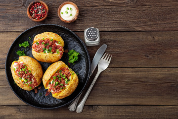 Baked stuffed potatoes with bacon, green onion and cheese, top view.
