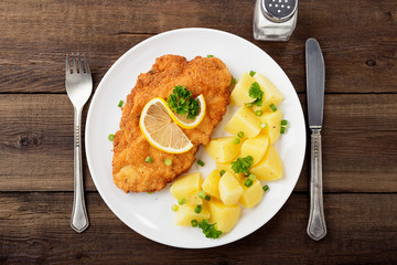 Homemade breaded german weiner schnitzel with potatoes. top view