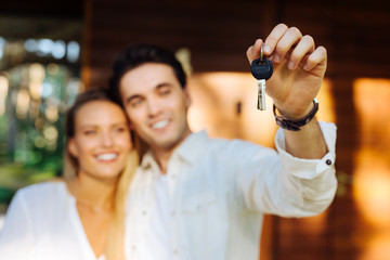 New home. Selective focus of keys of a new house held by a joyful nice couple