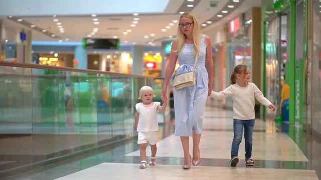 Shopping day of a modern family. Children At Mall With Mother. Happy family doing shopping. Family in mall. slow-motion