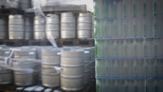 Packed bottles of beer and barrels and at the beer factory