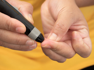 Fototapeta premium Close up shot of woman's hands making blood sugar level test