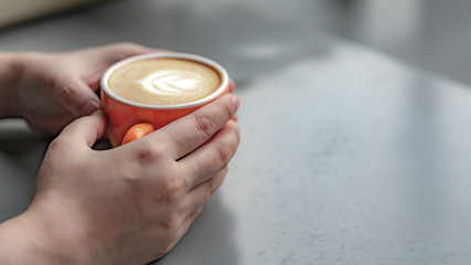 Hand Holding Hot Cappuccino Coffee