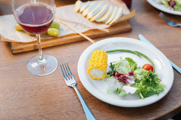 Delicious dish. Top view of healthy salad being served on the table with wine