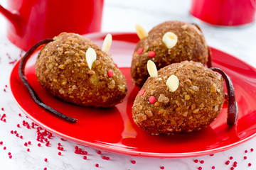 Chocolate mice cakes for Halloween , edible rat cakes on red plate , terrifying treats for Halloween party