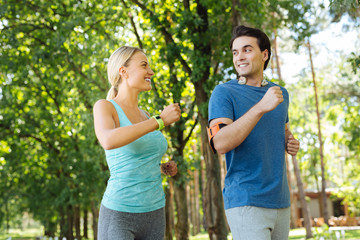 We are healthy. Delighted nice couple smiling while doing sports activities together
