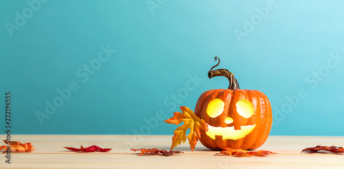 Halloween pumpkin with leaves on a blue background