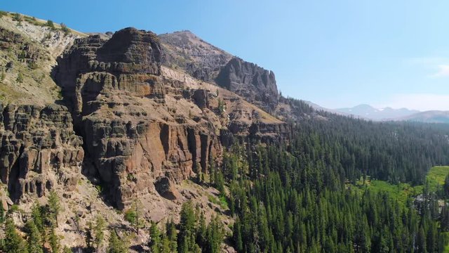 Aerial flight over high sierra mountain and green forest at 30 frames per second.