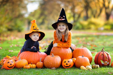 Kids with pumpkins in Halloween costumes