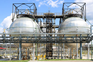 A large round ball-shaped shiny metallic high-pressure iron storage tank for ammonia is strong with...