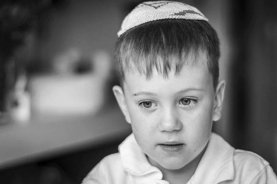 A beautiful Caucasian kid with a traditional Jewish kippah cap on his head. A Russian-speaking Jew in Israel portrait. Post-Soviet Jews make up over 15 per cent of Israeli society. Black and white
