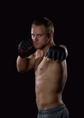 Fototapeta na wymiar Young well muscled Caucasian adult male wearing mma gloves throwing a left jab