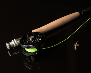 Fly rod and reel on black background