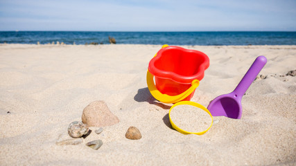 Spielsachen aus Plastik im Sand am Strand