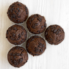 Chocolate muffins on white wooden background, view from above. Flat lay, overhead, top view. Closeup.