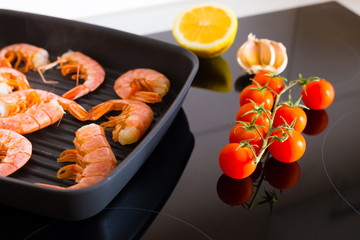 Food. Langoustines, induction stove, vegetables, grill pan