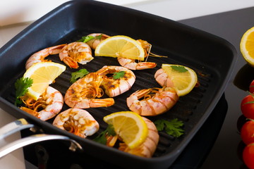 Food. Langoustines, induction stove, vegetables, grill pan