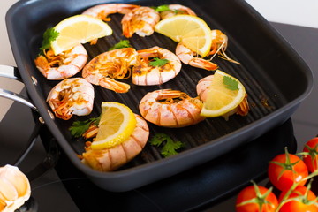 Food. Langoustines, induction stove, vegetables, grill pan