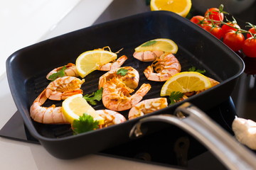 Food. Langoustines, induction stove, vegetables, grill pan