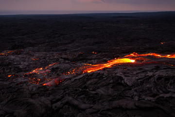 Overview of glowing lava flow from Puu Oo in the evening on the Pali in Kalapana, Big Island,...