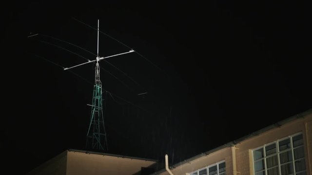 A radio mast in the rain, shot at night. A moody and mysterious scene.
