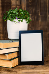 Ebook, digital tablet device, with old real books nearby