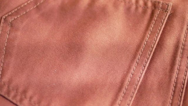 Orange fabric textile pants with pockets turns as background