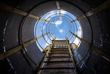 A inside view of tower/factory/industrial stair witrh blue sky