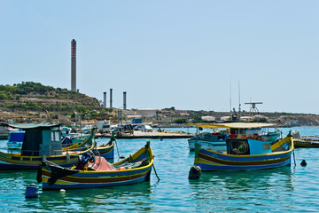Fototapeta na wymiar Traditional colorful boats in the Harbor of Mediterranean fishing village Marsaxlokk, Malta