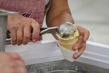 Hands of women serwing ice cream in waffle cone
