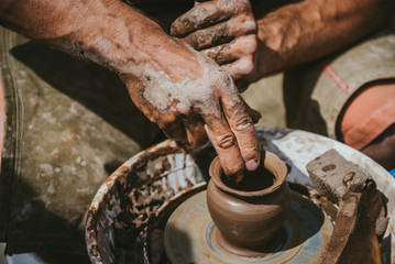 Master hands makes a pot of clay. Master class is held in nature, close-up
