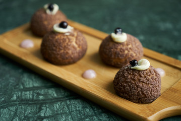 White chocolate profiteroles with peach violet. Cake Brioche shu cream chantilly, eclair. Sweet breakfast dessert 