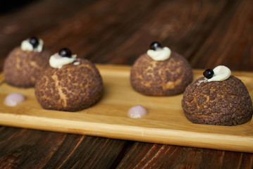 Fresh White chocolate profiteroles with peach violet. Cake Brioche shu cream chantilly, eclair. Sweet breakfast dessert 