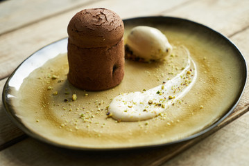 Fondant cake dessert and pistachio ice cream with English cream, pistachio crumble and sauce bailies