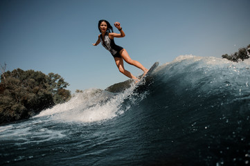 Naklejka na ściany i meble Girl riding on the wakeboard on the lake