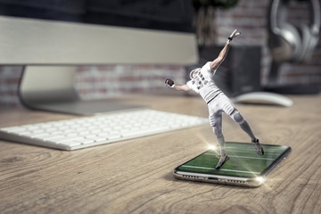 Football Player with a white uniform playing and coming out of a full screen phone on a wooden...