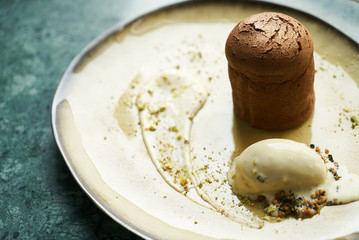Dessert Fondant cake and pistachio ice cream with English cream, pistachio crumble and sauce bailies