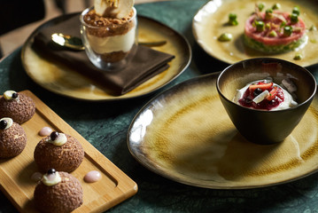 Sweet dessert food snack set on restaurant table, close-up. Ice cream, profiteroles cake, new york cheesecake. Healthy delicious breakfast 
