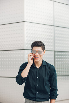 Cheerful man speaking on phone on street