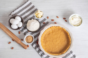 Baking sweet cheesecake with cooking ingredients on kitchen table